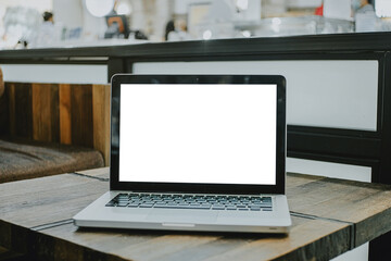 Fototapeta premium Blank screen laptop computer set up for work on a wooden desk. 