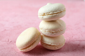 Concept of tasty dessert with macaroons on pink background