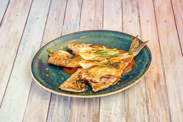 Super fish dish with recipe for grilled dorada fish with grilled chives and tomato cream on a blue plate.