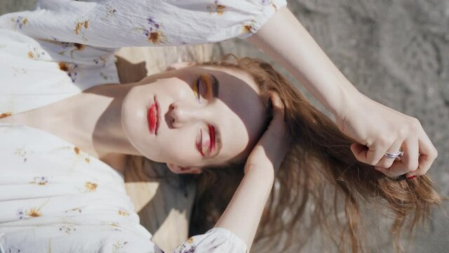 Top View Of A Woman In A White Dress On The Sand. Portrait In Nature