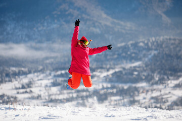 Alpine skier jumping against the background of a winter mountain landscape.