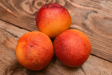 ripe yellow apricots with water drops on brown plank table 