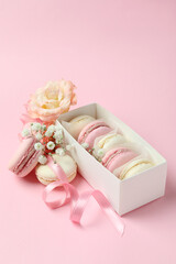 Concept of tasty dessert with macaroons on pink background
