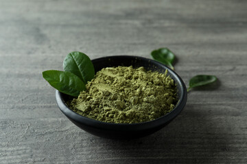 Plate of matcha powder on gray textured background