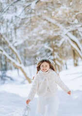 Amazing little girl holding Christmas lantern outdoors on beautiful winter sunny day