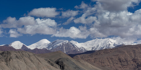 Scenic high altitude landscape near Kyzyl Art pass on Pamir Highway with snow covered mountain range, Murghab, Gorno-Badakshan, Tajikistan