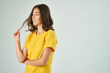 pretty brunette holding hair in yellow t-shirt modern style