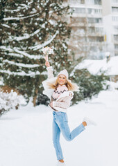 Beautiful woman posing near snow-covered Christmas trees in winter park.