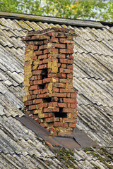 Naklejka premium A dilapidated old chimney on a summer day