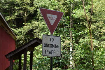 Yield to oncoming traffic next to covered bridge