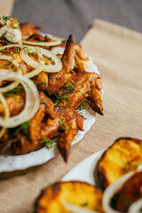fried chicken wings with onions cooked on the grill