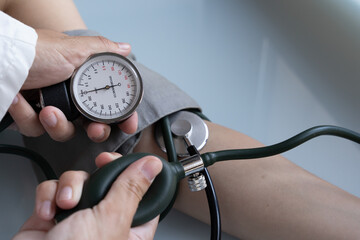 Doctor measuring blood pressure of a young woman