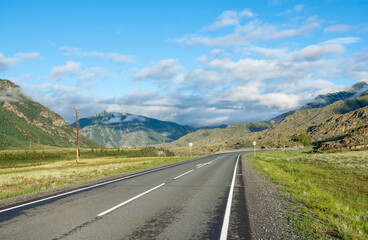 asphalt road in the mountains leading to the mountain peaks