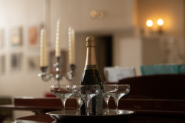 A tray with glasses of champagne and a bottle of sparkling wine.