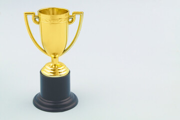 Champion golden trophy cup on blue background with copy space for text