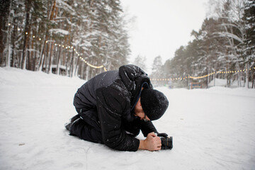Fototapeta na wymiar Videographer sits in the snow