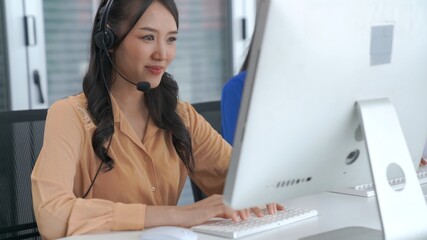 Businesswoman wearing headset working actively in office . Call center, telemarketing, customer...