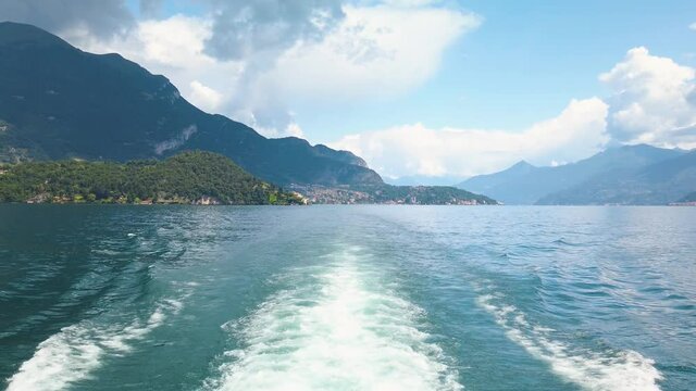 Clip of small waves on the Como lake, after a tourist ferry. The boat is sailing with tourists between the cities. It is a beautiful sunny summer day
