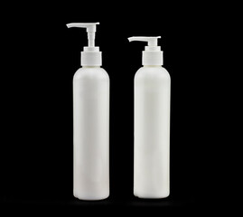 Two white bottles for cosmetics on a black background 