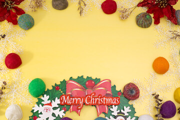 Top view of Christmas background. Decorative yellow background in yellow with colorful balls and dried flowers. 