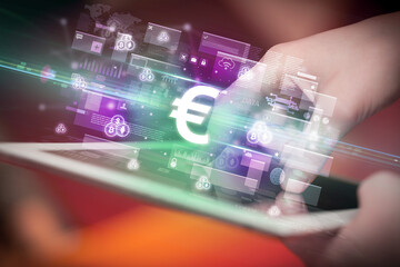 Close-up of a hand using tablet, currency concept