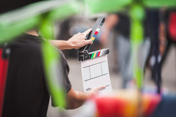 Filming on location. Man holding a clapperboard in front of the camera, the filming process. Scene...