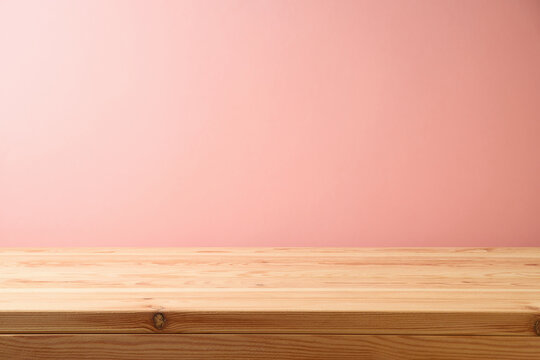Empty wooden table over pink wall background.  Interior mock up for design and product display.