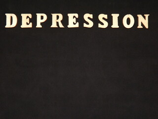 Fototapeta premium mental illness depression in wooden letters on a black background. High quality photo