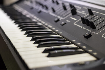 Electronic synthesizer keys close-up. Blurred background. The concept of creating music.