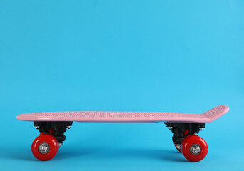 Pink skateboard on light blue background. Space for text