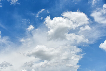 Beautiful cumulus clouds against the blue daytime sky.