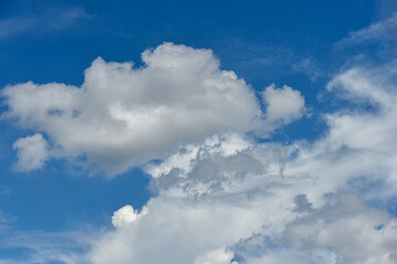 Beautiful cumulus clouds against the blue daytime sky.