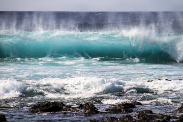 Naklejka premium sea landscape, blue sea waves crashing against the rocks, big turquoise wave in the ocean