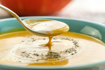 Close-up of a spoon with pumpkin soup on it