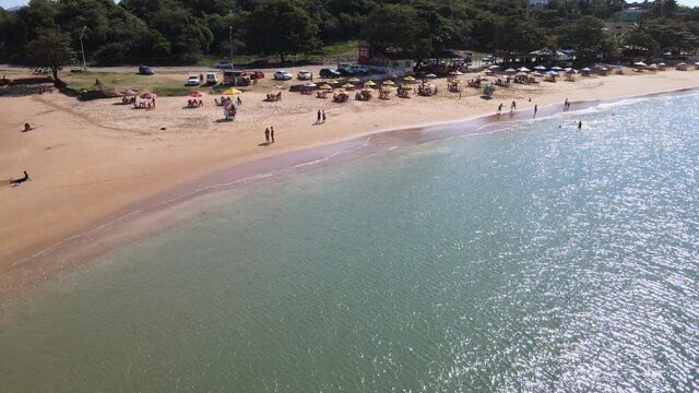 Visão aérea da praia de Setiba, na reginão norte de guarapari, mostando um dia ensolarado com barraquinhas e uma praia tropical deserta. Turismo no Espírito Santo.