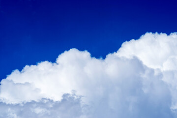 Naklejka na ściany i meble A blue sky with large fluffy white cloud