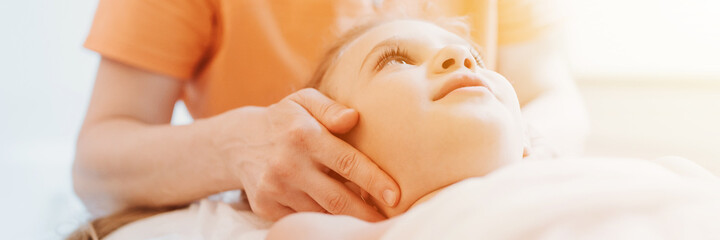 real doctor osteopath hands does physiological therapy for eight year old kid girl. pediatric...