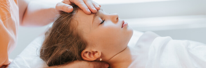 doctor osteopath hands does physiological and emotional therapy for eight year old kid girl....