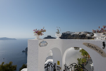 White top of buildings in Santorini, Greece with blue sky in a sunny warm day in July 2021.