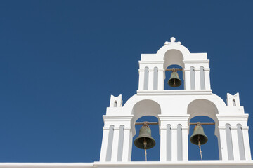 White top of buildings in Santorini, Greece with blue sky in a sunny warm day in July 2021.
