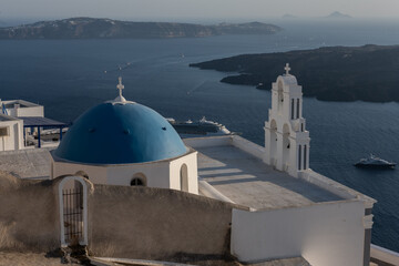 White top of buildings in Santorini, Greece with blue sky in a sunny warm day in July 2021.