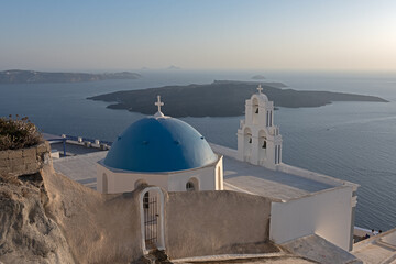 White top of buildings in Santorini, Greece with blue sky in a sunny warm day in July 2021.