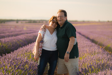 romantic lifestyle portrait of senior hispanic couple happy and relaxed at lavender flowers field enjoying retirement and celebrating aging together