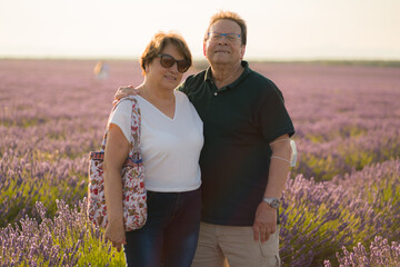 romantic lifestyle portrait of senior hispanic couple happy and relaxed at lavender flowers field enjoying retirement and celebrating aging together