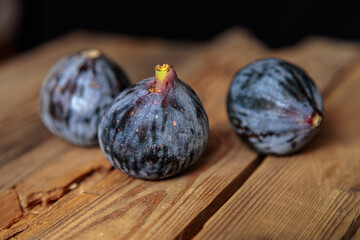 Fresh purple figs on a wooden background from old boards. Raw exotic figs.