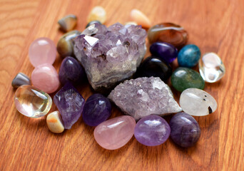 Gems of various colors. Amethyst, rose quartz, agate, apatite, aventurine, olivine, turquoise, aquamarine, rock crystal on wooden background
