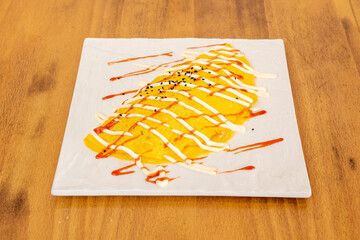 recipe for fried rice wrapped in an egg omelette with mayonnaise sauce and ketchup on top