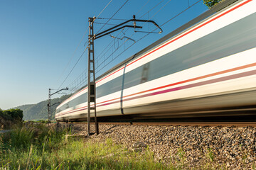 Close-up of a speeding train on a sunny morning.