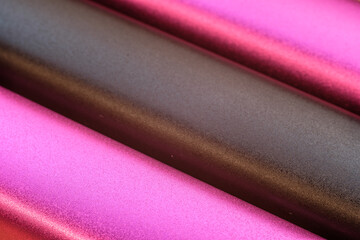 multi-colored aluminum rods, parallel to each other, close-up photo