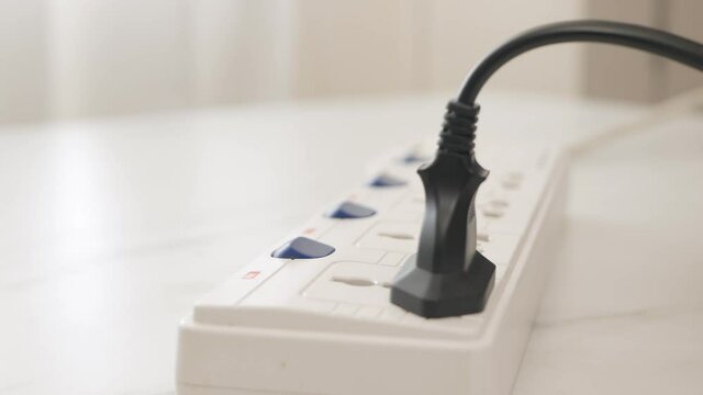 Close up Male hand plugging in a power cord on the table.